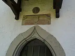 Westliches Kielbogenportal mit Inschrift und Christuskopf