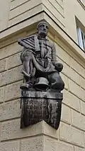 Kriegerdenkmal an der Scholastika des Akademischen Gesangvereins München mit einer Lyra, dem Symbol des AGV. Inschrift: "Ehr unser Zier, Lied das Panier, That unser Wort, Gott unser Hort!"