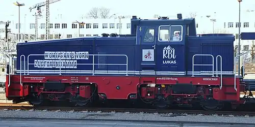 blau-rote Diesellokomotive mit weißen Beschriftungen auf einem Gleis
