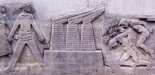 Detailaufnahme des Reliefs: Stilisierte Öfen mit den Namen der Konzentrationslager