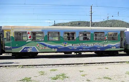 Hinter dem Waggon „Kirchberg an der Pielach“ steht ein Vierachser der Mariazellerbahn (1908), der in den 1960er Jahren einen Wagenkasten-Neuaufbau in Spantenbauweise erhielt.