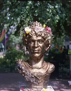Bronzestatue mit Blumenkranz
