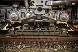 Dieses Bild zeigt eine hochaufgehängte Magnetschienenbremse, die sich im angelegten Zustand und somit auf dem Schienenkopf befindet.