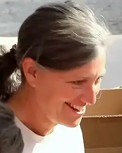 Tranel-Michini trägt ein weißes T-Shirt und schaut nach links.