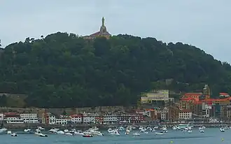 Blick über die Bucht auf Monte Urgull mit Castillo de La Mota und Jesus-Statue von Donostia