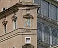 Farbfotografie vom oberen Teil eines Backsteingebäudes. Neben vier Fenstern, die sich auf drei Stockwerke verteilen, ist eine fenstergroße Malerei von Maria und Jesus mit einem dreieckigen Fenstergiebel. Unter der Malerei befindet sich ein blau-gelbes Wappen und rechts davon die Aufschrift „Totus Tuus“. Unter dem Fenster mit der Malerei steht „Mater Ecclesiae“.