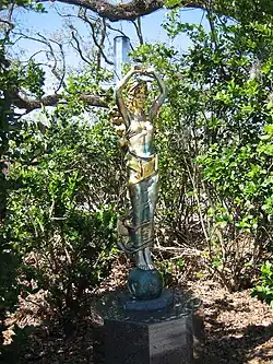Skulptur Civitas von Audrey Flack im New Orleans Museum of Art Sculpture Garden im City Park - eine bronzefarbene Statur einer Frauengestalt mit erhobenen Armen, einen Kristall oder Eisblock in ihren Händen tragend