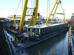 Die gehobene Pure-Liner 2 an den Haken der Schwimmkräne HEBO-Lift 6 und HEBO-Lift 7 und beim Auspumpen.