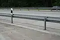 In Boden­hülsen gesteckte Leit­planken und durch­gehend betonierter Mittel­streifen