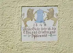 Haustafel an einer Gaststätte in Oberbachern mit der Inschrift „1848 Solche Gäste liebe ich, die Essen und Trinken und zahlen mich“