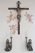 Kruzifix, Leuchterengel und gemalte Putten