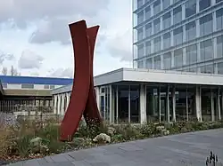 Die Fotografie zeigt die Skulptur ohne Titel (Jin, Mensch) des Künstlers Ernst Hesse vor einem Gebäude in Duisburg.