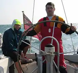 Steuerrad eines Segelschiffs. Gut erkennbar ist die Marke, mit der die Neutrallage des Ruders identifiziert werden kann