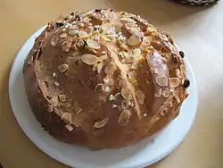 Ein Osterfladen mit Mandelblatt- und Hagelzuckerverierung auf einem weißen Teller