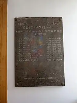 Diese Tafel erinnert an die Pfarrer dieser Gemeinde, Foto April 2025