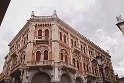 Der Palazzo delle Debite von Südosten aus gesehen mit der Süd- und Ost-Fassade und der Übergansfassade im Südosten. Es ist ein dreistöckiges Gebäude mit Doppel-Bogenfenstern und vielen Verzierungen, Pilastern und Stuckrosetten, sowie Löwenköpfen am Erdgeschoss.