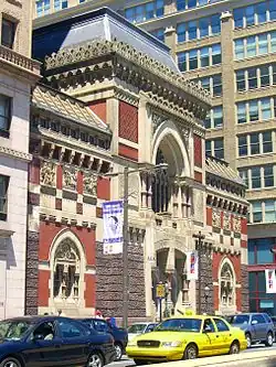 Historismus, Pennsylvania Academy of the Fine Arts, (1872–1876) von Frank Furness: „Der kühne, äußerst eklektische Entwurf weist eine auffallende Fassade mit einer Mischung aus Motiven des Islam, der Gotik und der Renaissance […] auf“.[14]