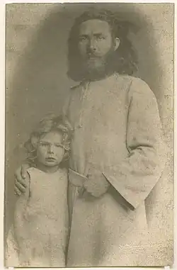 Der 34-jährige Diefenbach in Reformkutte. Er legt den Arm um ein ebenfalls mit einer Kutte bekleidetes blondes Kind.