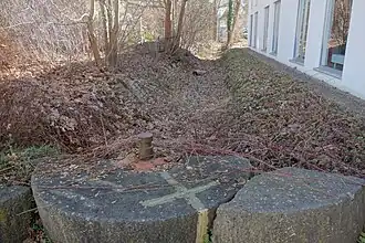 Mühlsteine am trockengelegten Pilsach-Leitgraben vor dem Hauptgebäude