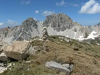 Steinmann auf dem Piz Settember. Im Hintergrund der Piz digl Gurschus.