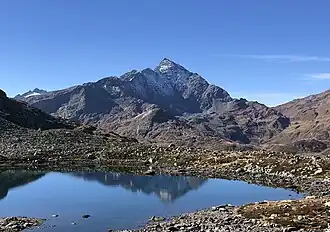 Pizzo Tambo von Nordosten. Rechts unter dem Aufschwung zum Berg befindet sich die Tamboalp. Im Vordergrund der Under Surettasee