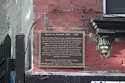 Eine Gedenktafel mit der Inschrift: „An extraordinary figure in the socialist and anarchist movements of the late 19th century, German-born Justus H. Schwab lived with his family and operated a saloon at 50 East 1st Street for nearly 30 years. Schwab's saloon was an epicenter for social radicalism and was frequented by anarchist Emma Goldman and writer Ambroce Bierce among many others. Schwab contributed significantly to the reputation of the Lower East Side and present-day East Village as a center of transformative social and political movements.“