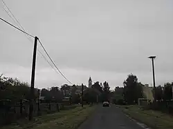 Dieses Bild in schwarzweiß zeigt eine Straße in der Gemeinde Leles, welche im Osten der Slowakei liegt. (Pohľad na kláštor v Lelesi) und wurde 2015 aufgenommen.