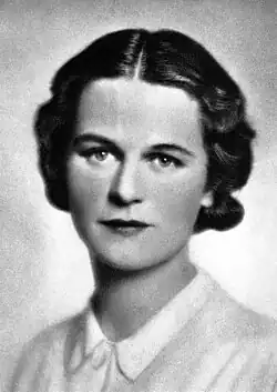 Fotografie einer 29-jährigen, akkurat gekleideten und frisierten Frau mit konzentriertem Gesichtsausdruck