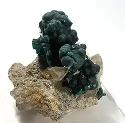 Von farblosem Cerussit begleitete kugelig-nierige Pseudomalachit-Aggregate aus der Broken Hill Proprietary Mine, Broken Hill in New South Wales, Australien (Größe: 4 cm × 3,8 cm × 2,7 cm)