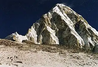 Nordgipfel des Kala Patthar (schwarzbraun) vor dem Pumori, etwas rechts oberhalb der Trekkinggruppe; der Südgipfel befindet sich am linken Bildrand
