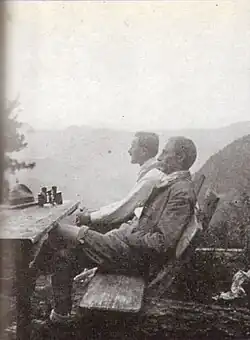 Zwei Männer sitzen vor einer Berghütte