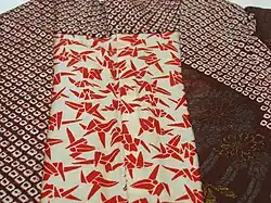 Kastanienbraunes kurzes Seidengewand, weiße Shibori-Flecken und große Rondelle oder brokatierte Blumenmuster, teilweise gefüttert.