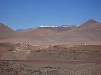 Rechts am Horizont der Gipfel Pico El Laco, links daneben mit den schwarzen Zonen Cerro Laco Sur und Cerro Laco Norte. Das Bild zeigt nur etwa die Hälfte des Vulkankomplexes.