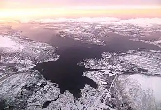 Reisafjord (vorn), Solbergfjord (links), Finnfjord (rechts), die Insel Senja (oben im Hintergrund)