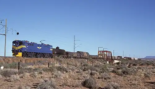 E7008 im blauen Spezialanstrich der SAR für den Einsatz vor dem Blue Train, aber vor einem Güterzug bei Die Put, ungefähr 16 km südlich von De Aar, eingesetzt, am 2. Mai 1985