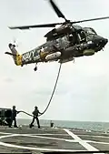 Betankung eines über dem Flugdeck schwebenden Hubschraubers des Typs Seasprite (Helicopter In-Flight Refueling, HIFR)