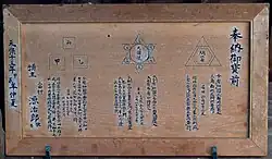 Dunkelbraune Holztafel mit drei Geometrie-Illustrationen (einander berührende Quadrate, Kreise und Dreiecke) und japanischen Schriftzeichen
