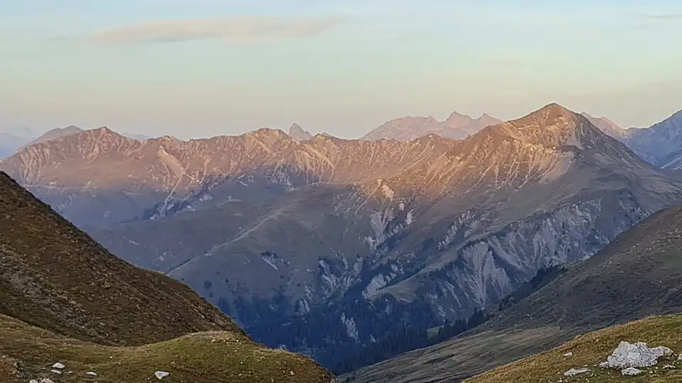 Die Sonne erhellt den Grat zwischen Sassauna (l.) und Girenspitz (r.), im Hintergrund Vilan, Glegghorn, Falknis und Naafkopf, aufgenommen von der Carschinahütte (für Annotationen der einzelnen Berge aufs Bild klicken)