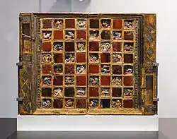 Ansicht der Schachseite eines großen, mit wertvollen Materialien erstellten Spielbretts, das aufrecht in einer Vitrine steht