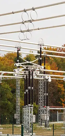 Eine Gruppe von drei Trennern (Bauart Pantograf- oder Scherentrenner, geöffnet) in einer Freiluftschaltanlage für 380 kV