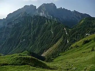 Blick von Norden auf Pelf (links) und La Schiara (Mitte), davor Cime de la Scala. Rechts am Fuß des Gipfelaufbaus von La Schiara steht die Felsnadel Gusèla del Vescovà.