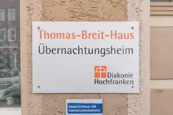 Das Foto zeigt das Schild, das darauf hinweist, dass hier das Übernachtungsheim (Thomas-Breit-Haus) ist
