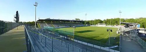 Blick auf Spielfeld und Tribünen von der Stehtribüne West