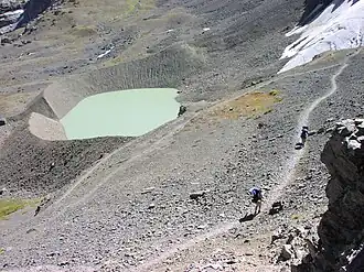 Der Teton Crest Trail mit dem Schoolroom Glacier (rechts oben) und dem entstandenen Karsee (links)