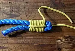 Man zieht an beiden Enden der dickeren Leine und zieht die Windungen hoch und zieht den Knoten fest.