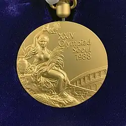 Foto einer goldenen Medaille mit dem Aufdruck „XXIV Olympiad Seoul 1988“