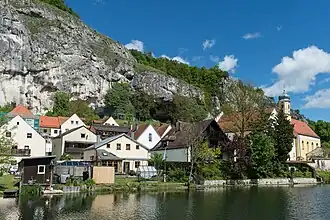 Die Sesselfelsgrotte (Bildmitte links unter dem Steinschlag-Schutznetz) und der „Abri im Dorf“