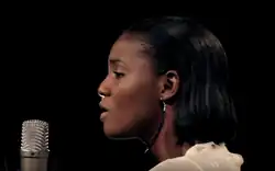 Seitliches Porträt von Simi, in ein Mikrofon singend