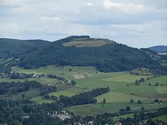 Blick vom Wachtküppel südostwärts zum Simmelsberg; vorne Häuser von Gersfeld, mittig rechts der waldlose Rodenbacher Küppel mit Häusern von Rodenbach, mittig links der Dammelhof