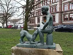 Skulptur, Schüler und Hund, 1926, St. Johanns-Platz in Basel. Von Franz Wilde (1895–1980) Plastiker.